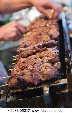Stock Photo - Kebab being cooked on grill. Fotosearch