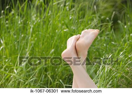 Stock Image - Legs of a person in field. Fotosearch