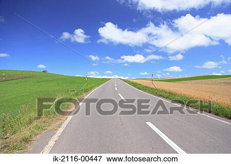 Long empty road with grassland against cloudy sky View Large Photo Image Stock Photo - Long empty road with grassland against cloudy sky. Fotosearch