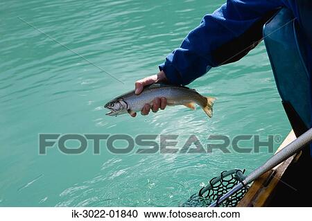 Stock Image - Man Holding Fish in Hand. Fotosearch