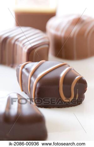 Stock Photograph - Milk Chocolate Pieces on White Surface. Fotosearch