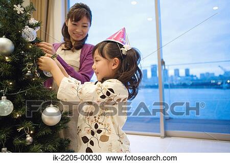 Mother and daughter decorating xmas tree View Large Photo Image Stock Image - Mother and daughter decorating xmas tree. Fotosearch