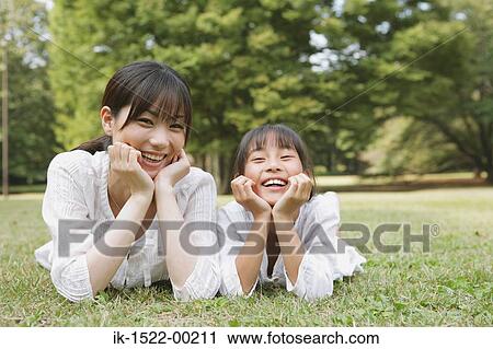Mother and Daughter Laying Down on Grass View Large Photo Image Stock Image - Mother and Daughter Laying Down on Grass. Fotosearch