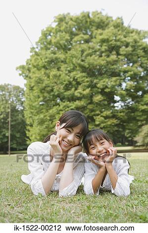 Mother and Daughter Laying Down on Grass View Large Photo Image Stock Image - Mother and Daughter Laying Down on Grass. Fotosearch