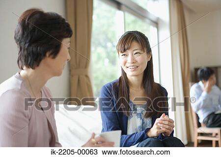 Mother and daughter sitting in living room View Large Photo Image Stock Image - Mother and daughter sitting in living room. Fotosearch