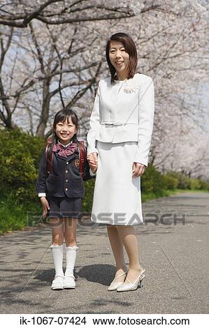 Mother and daughter standing on road View Large Photo Image Picture - Mother and daughter standing on road. Fotosearch