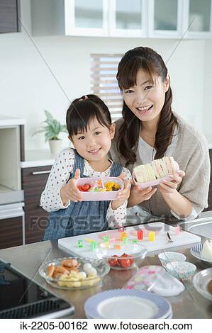 Mother with daughter packing lunch box View Large Photo Image Stock Image - Mother with daughter packing lunch box. Fotosearch