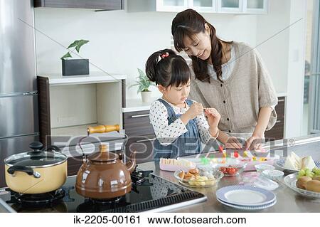 Mother with daughter preparing food View Large Photo Image Stock Image - Mother with daughter preparing food. Fotosearch