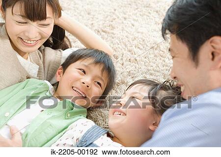 Parents with their children lying on carpet View Large Photo Image Stock Image - Parents with their children lying on carpet. Fotosearch