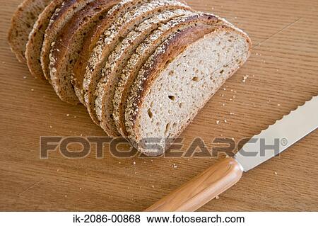 Stock Photo - Pieces of Bread on Breadboard with Knife . Fotosearch