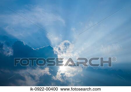 Stock Image - Rays of Sunlight Beam Passing Through Cloudy Sky . Fotosearch