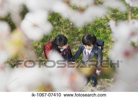 Stock Image - Schoolmate holding hands and going to school. Fotosearch