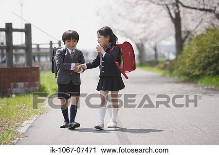 Schoolmate holding hands and walking together View Large Photo Image Stock Image - Schoolmate holding hands and walking together . Fotosearch