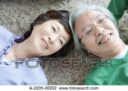 Senior couple lying head to head on carpet View Large Photo Image Stock Image - Senior couple lying head to head on carpet. Fotosearch