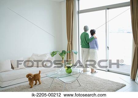 Stock Image - Senior couple standing in front door. Fotosearch