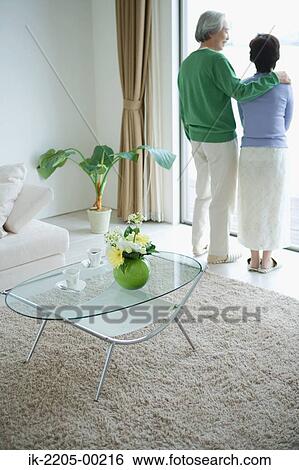 Stock Photograph - Senior couple standing in front door. Fotosearch