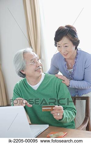 Senior man showing laptop to his wife View Large Photo Image Stock Photography - Senior man showing laptop to his wife. Fotosearch