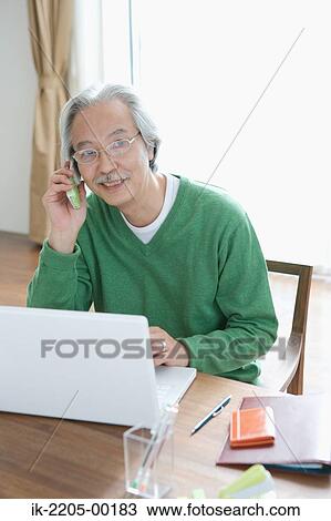 Stock Image - Senior man using his cell phone and smiling. Fotosearch