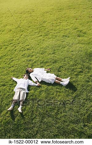 Siblings Laying Down on Grass View Large Photo Image Stock Image - Siblings Laying Down on Grass. Fotosearch
