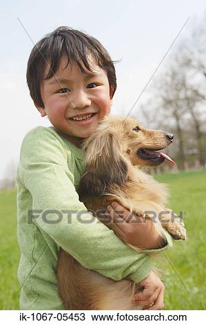Smiling boy holding pet dog View Large Photo Image Stock Image - Smiling boy holding pet dog. Fotosearch