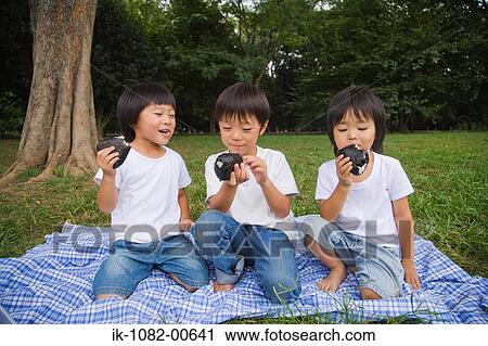 Smiling boys enjoying chocolate cake in park View Large Photo Image Stock Image - Smiling boys enjoying chocolate cake in park. Fotosearch