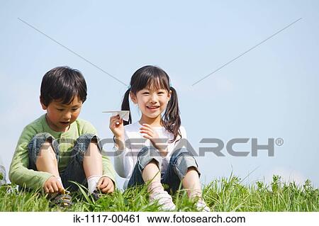 Stock Image - Smiling children playing in park together. Fotosearch