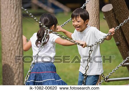 Stock Image - Smiling children playing on jungle gym. Fotosearch