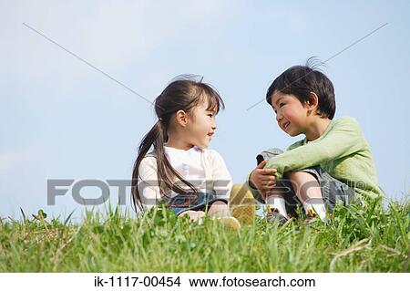 Smiling children sitting in park together View Large Photo Image Picture - Smiling children sitting in park together. Fotosearch