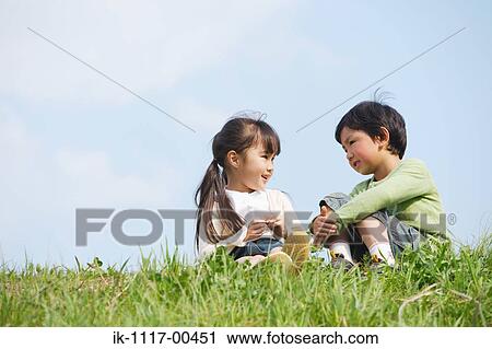 Stock Image - Smiling children talking in park. Fotosearch