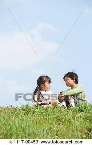 Stock Image - Smiling children talking in park. Fotosearch