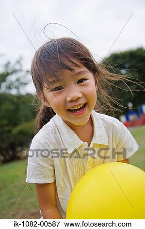 Smiling girl holding balloon View Large Photo Image Stock Photo - Smiling girl holding balloon. Fotosearch