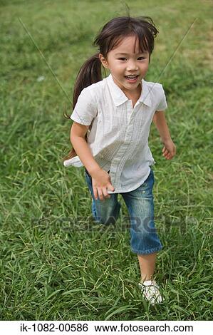 Smiling girl running in park View Large Photo Image Stock Photograph - Smiling girl running in park. Fotosearch