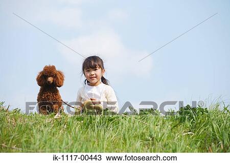 Smiling girl sitting with a cute puppy in park View Large Photo Image Stock Image - Smiling girl sitting with a cute puppy in park. Fotosearch