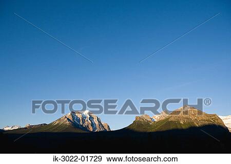 Snow -Covered Mountains against Blue Sky View Large Photo Image Stock Photo - Snow -Covered Mountains against Blue Sky . Fotosearch