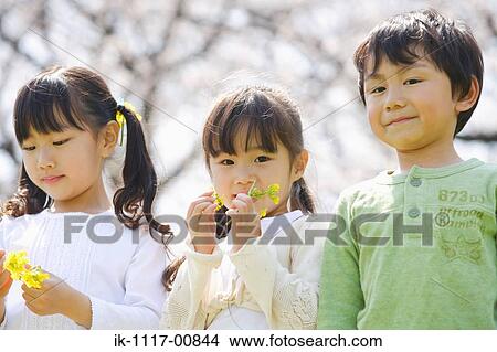 Picture - Three children holding flowers and enjoying together. Fotosearch