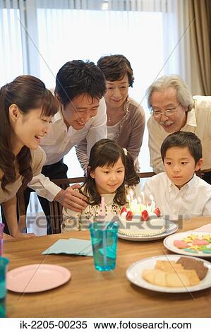 Stock Photography - Three generation family celebrating birthday at home. Fotosearch