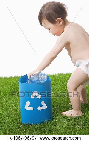Stock Photo - Toddler putting bottle in recycling bin. Fotosearch