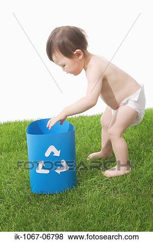 Toddler putting his hands in recycling bin View Large Photo Image Stock Photo - Toddler putting his hands in recycling bin. Fotosearch