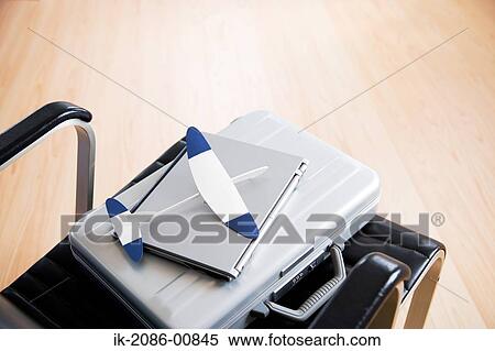 Stock Photography - Toy Airplane and Laptop with Briefcase Lying in the Chair. Fotosearch