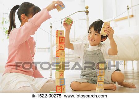 Stock Photography - Two Children Playing with Alphabet Blocks. Fotosearch