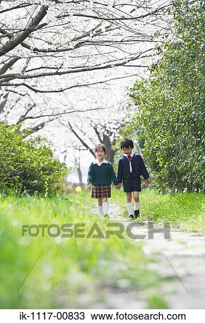 Two children walking in park holding hands View Large Photo Image Stock Image - Two children walking in park holding hands. Fotosearch