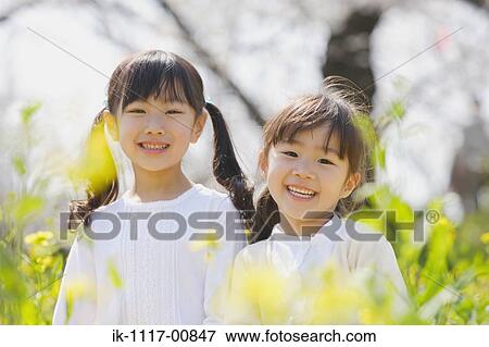 Stock Photo - Two cute Japanese girls smiling to camera. Fotosearch