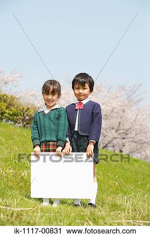 Stock Image - Two Japanese children holding white cardboard. Fotosearch