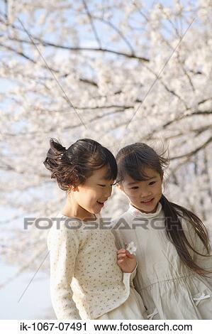 Two Japanese sisters smiling and looking down View Large Photo Image Stock Image - Two Japanese sisters smiling and looking down. Fotosearch
