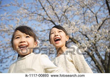 Two Japanese sisters smiling and laughing View Large Photo Image Stock Image - Two Japanese sisters smiling and laughing. Fotosearch