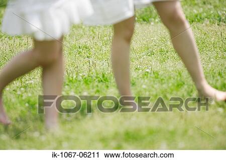 Two women standing in park View Large Photo Image Stock Image - Two women standing in park. Fotosearch