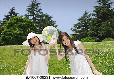 Two young smiling women holding ball View Large Photo Image Stock Image - Two young smiling women holding ball. Fotosearch