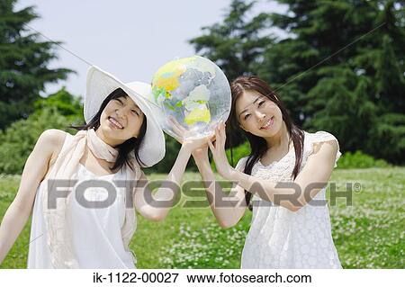 Stock Photo - Two young women holding ball. Fotosearch