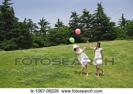 Stock Photograph - Two young women playing in park. Fotosearch