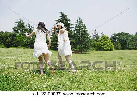Two young women running in park View Large Photo Image Stock Photo - Two young women running in park. Fotosearch